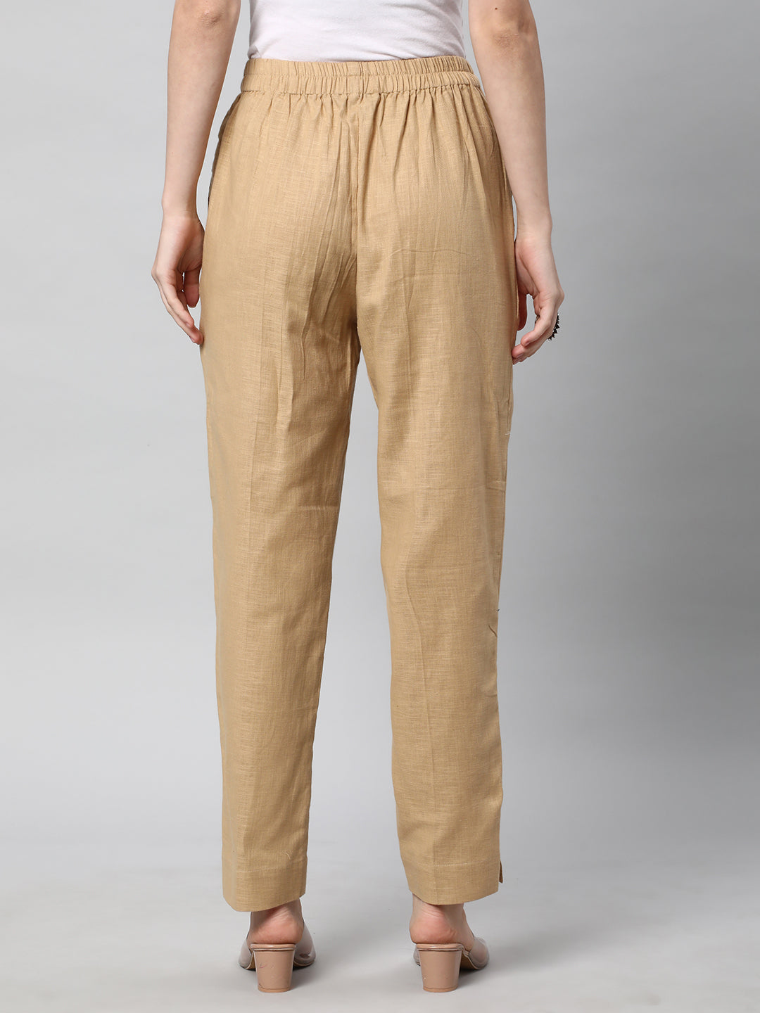 A beige ankle length cotton linen pant with plain belt in front