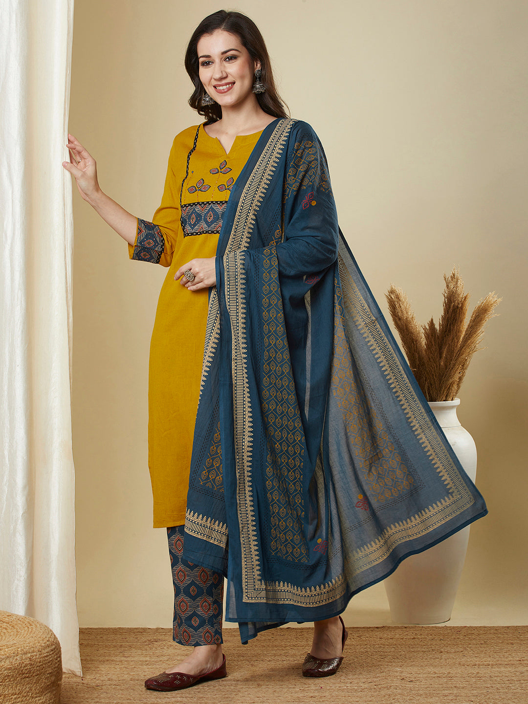 A mustard kurta suit set featuring a mix-match yoke and hand applique