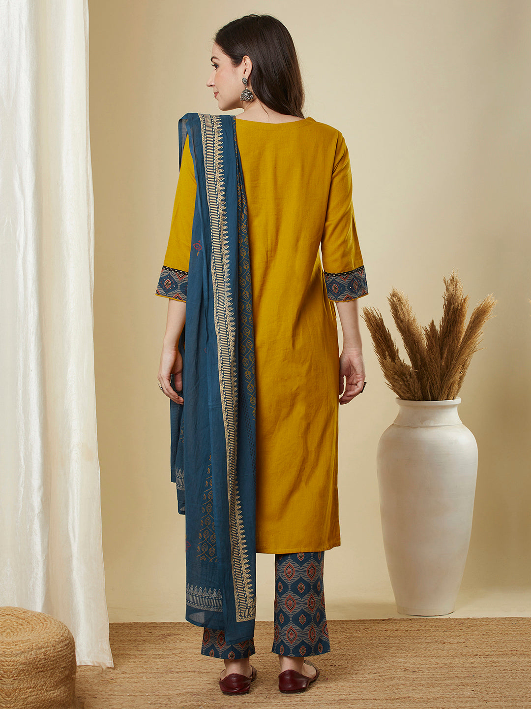 A mustard kurta suit set featuring a mix-match yoke and hand applique