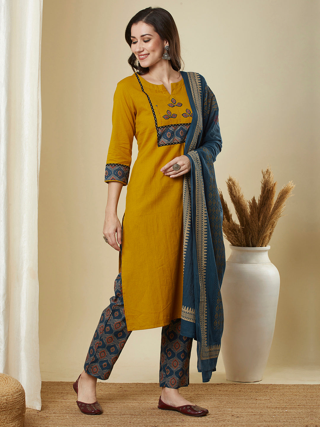 A mustard kurta suit set featuring a mix-match yoke and hand applique