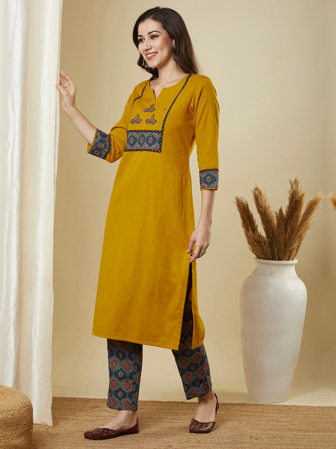 A mustard kurta suit set featuring a mix-match yoke and hand applique