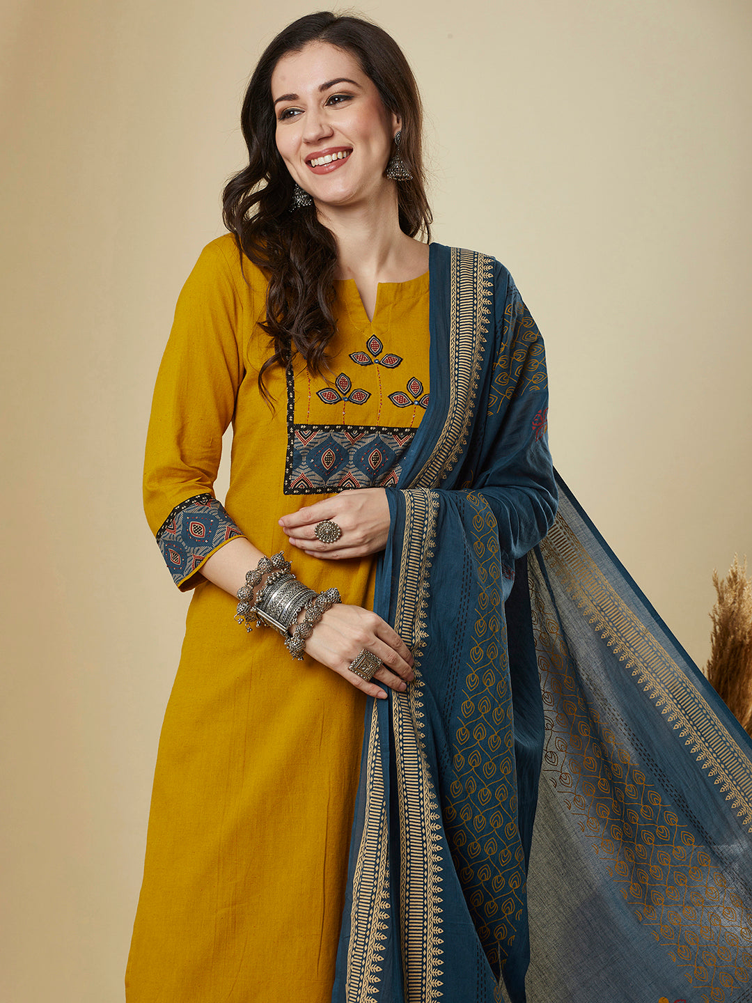 A mustard kurta suit set featuring a mix-match yoke and hand applique