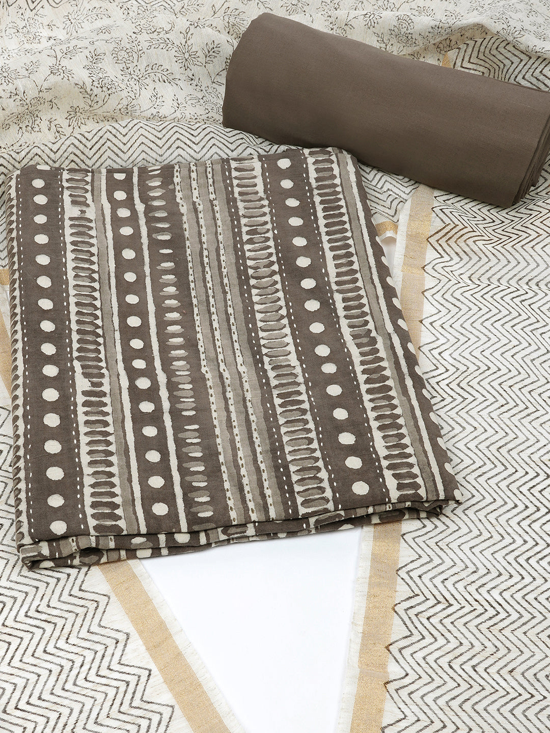 Brown unstitched suit set with traditional geometric dabu print along with printed dupatta and solid bottom