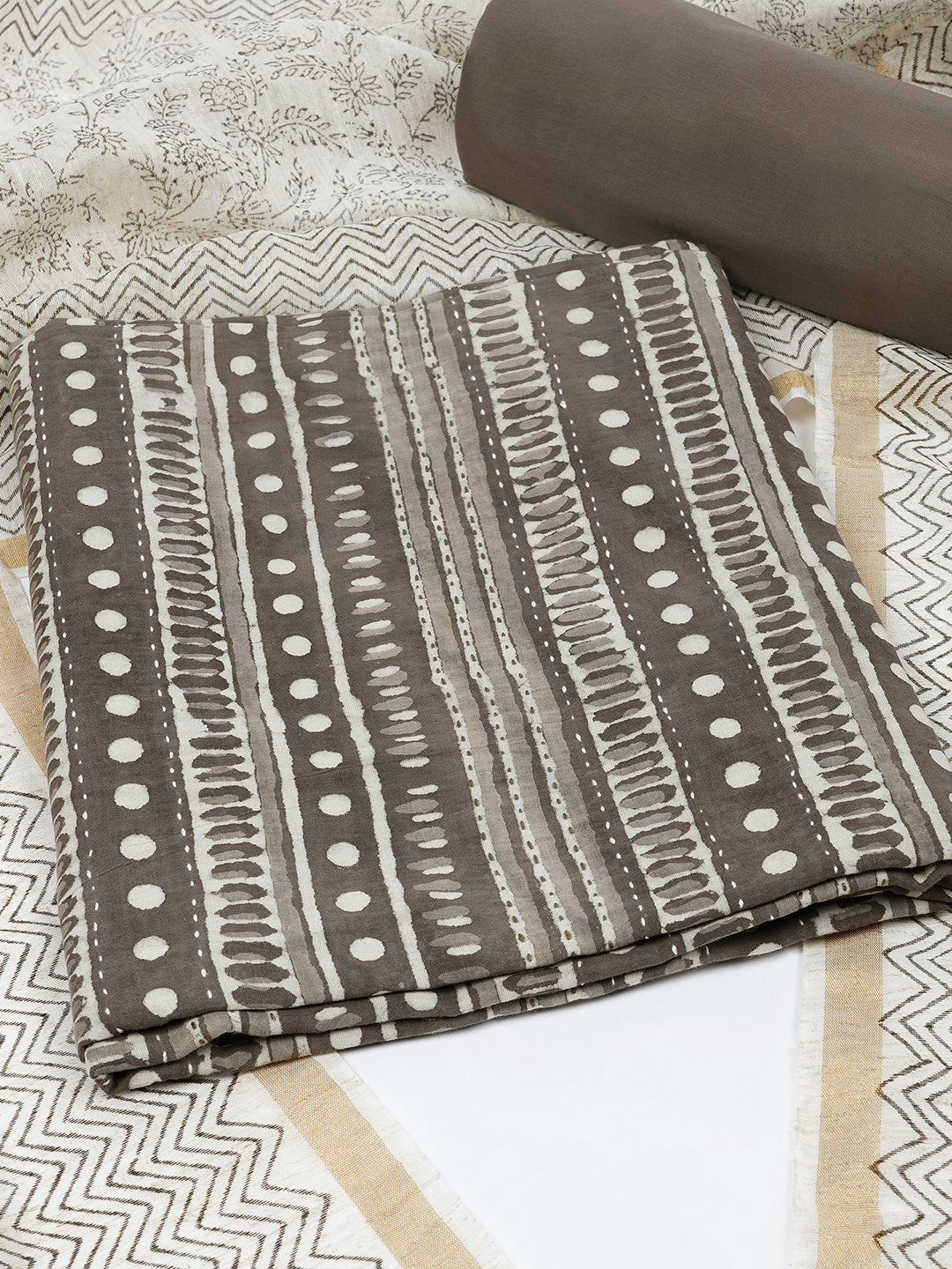 Brown unstitched suit set with traditional geometric dabu print along with printed dupatta and solid bottom