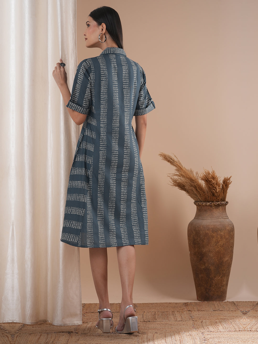 A collared printed dress with stripe manipulation panels, dual pockets and half sleeves with cuff