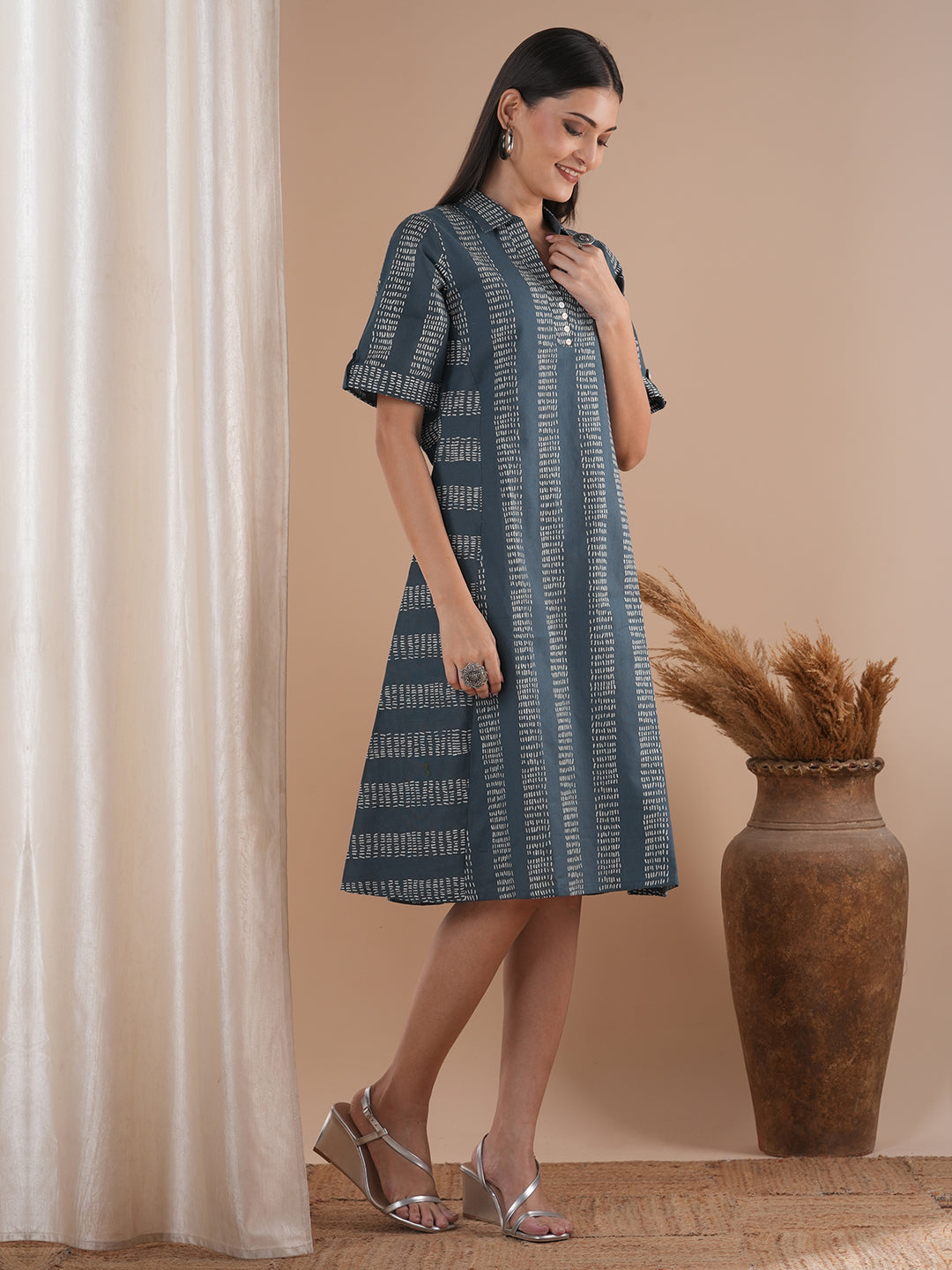 A collared printed dress with stripe manipulation panels, dual pockets and half sleeves with cuff