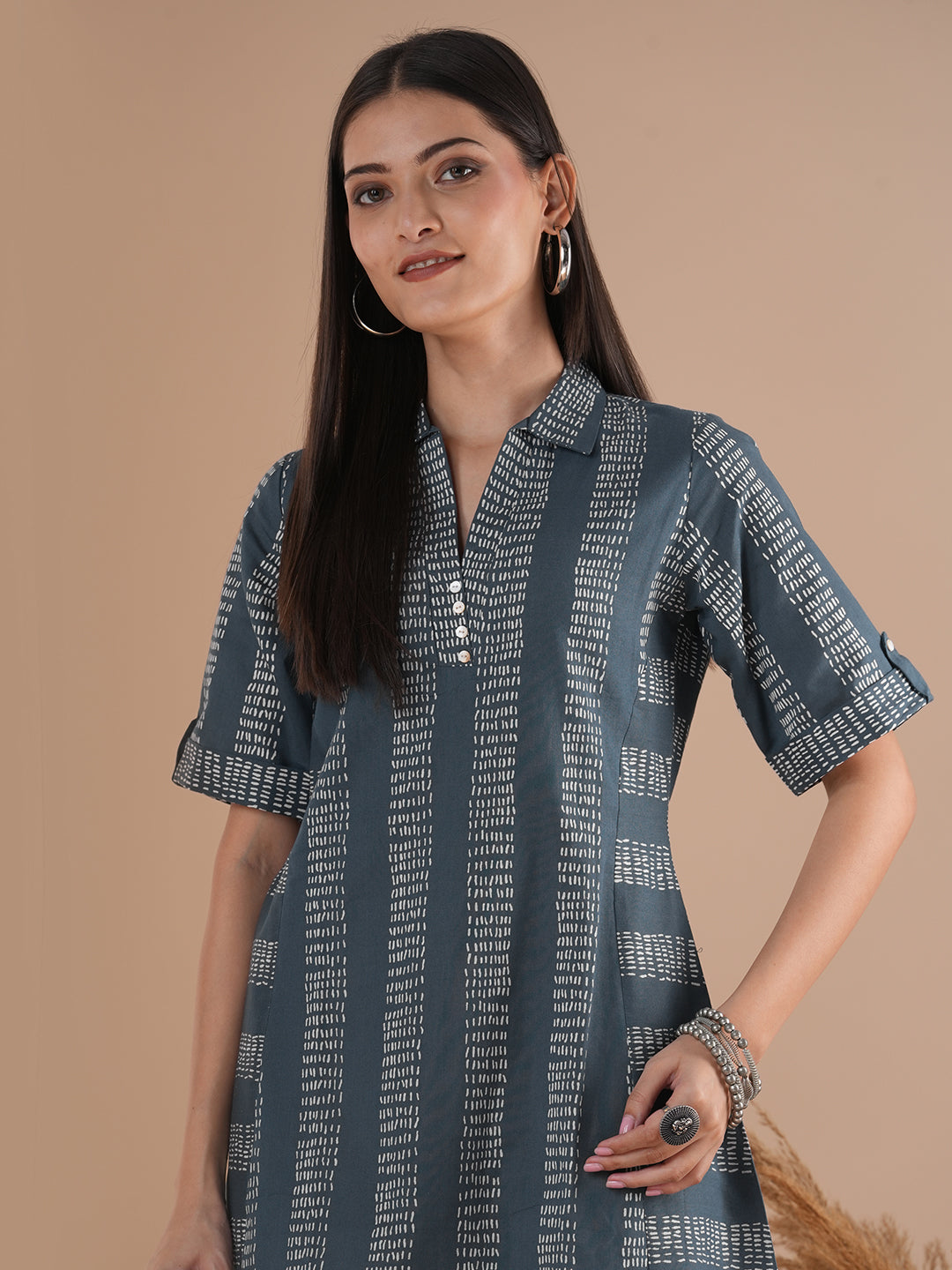 A collared printed dress with stripe manipulation panels, dual pockets and half sleeves with cuff