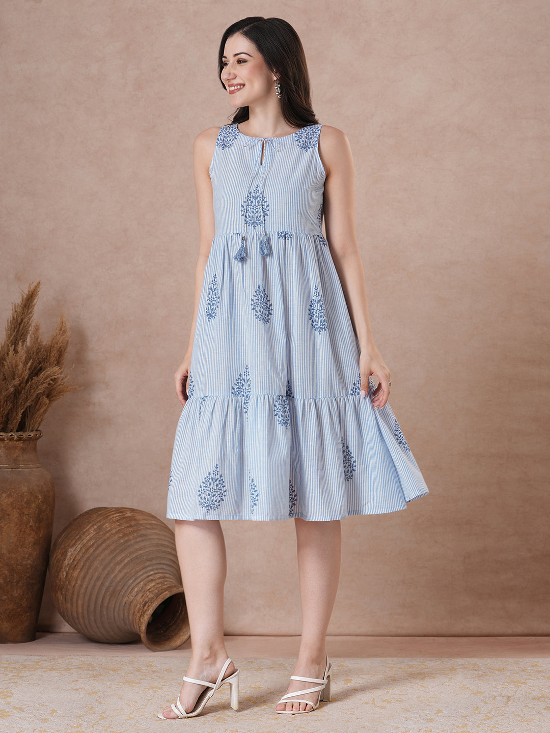 Woven striped and screen printed tiered dress with tie-up on neck with tassels.
