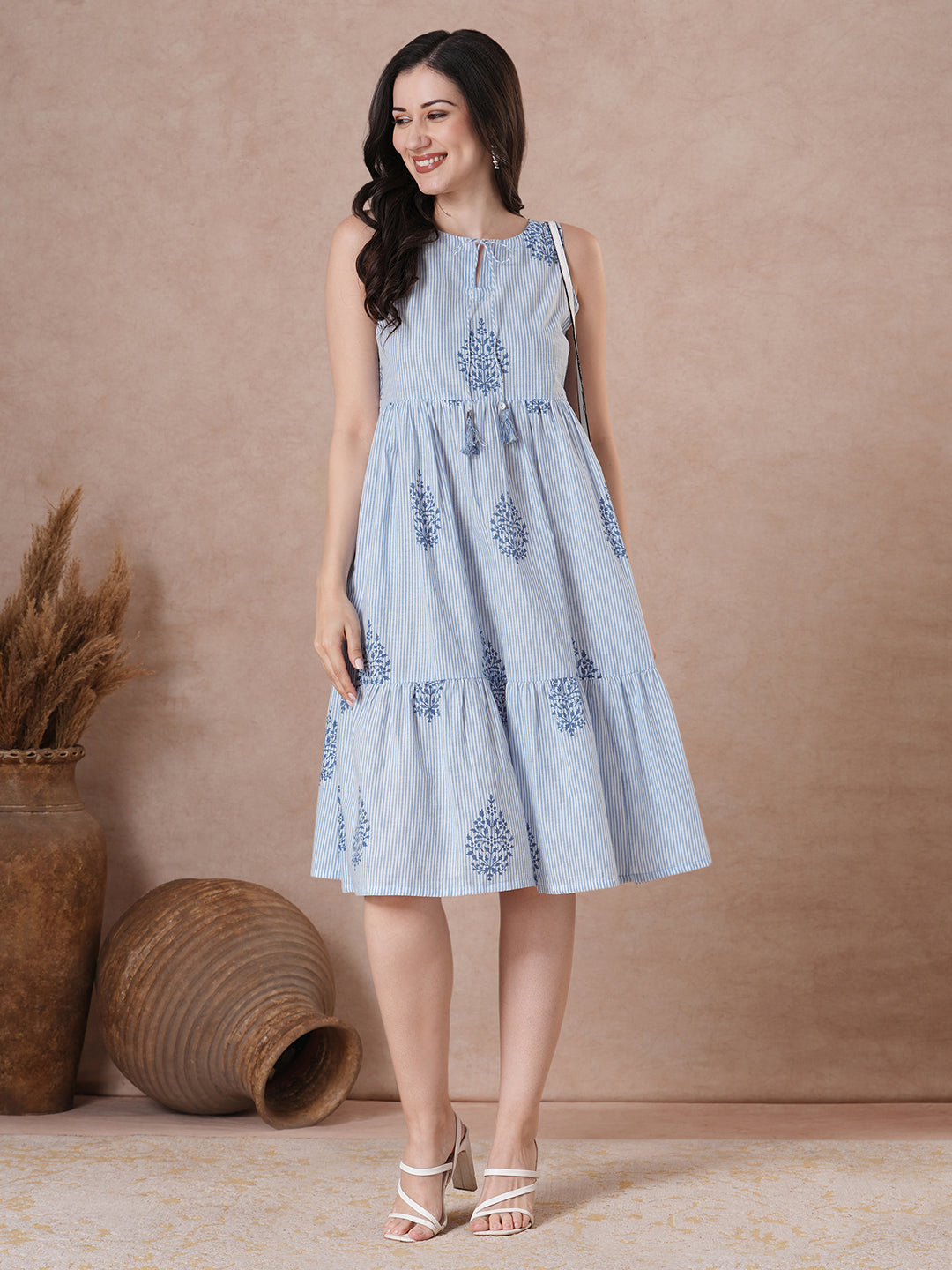 Woven striped and screen printed tiered dress with tie-up on neck with tassels.