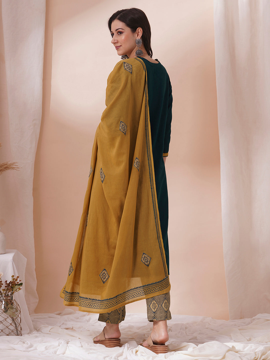 Forest green straight fit kurta suit set crafted with self dobby cotton fabric paired with geometric print bottom and applique dupatta.