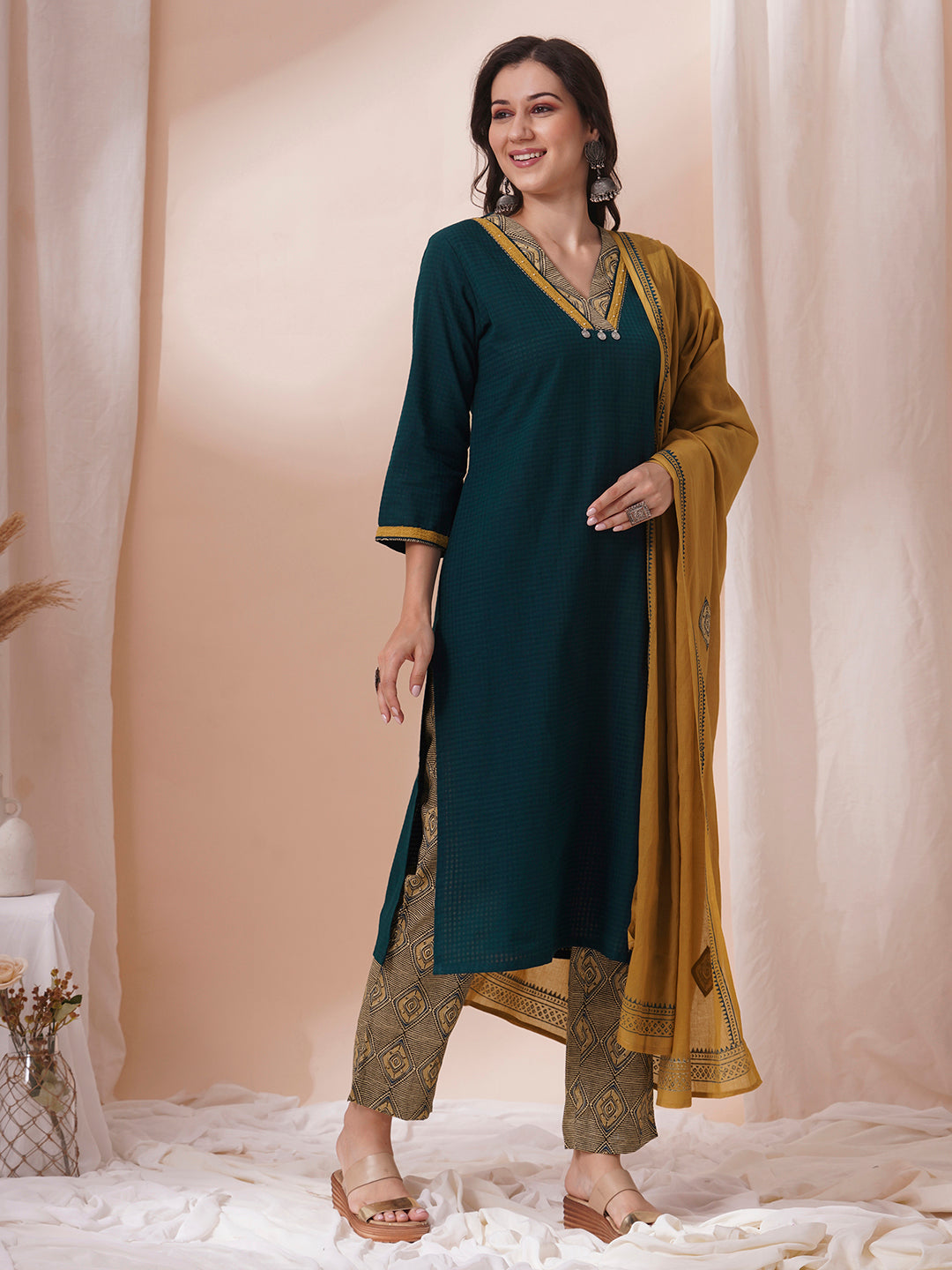 Forest green straight fit kurta suit set crafted with self dobby cotton fabric paired with geometric print bottom and applique dupatta.