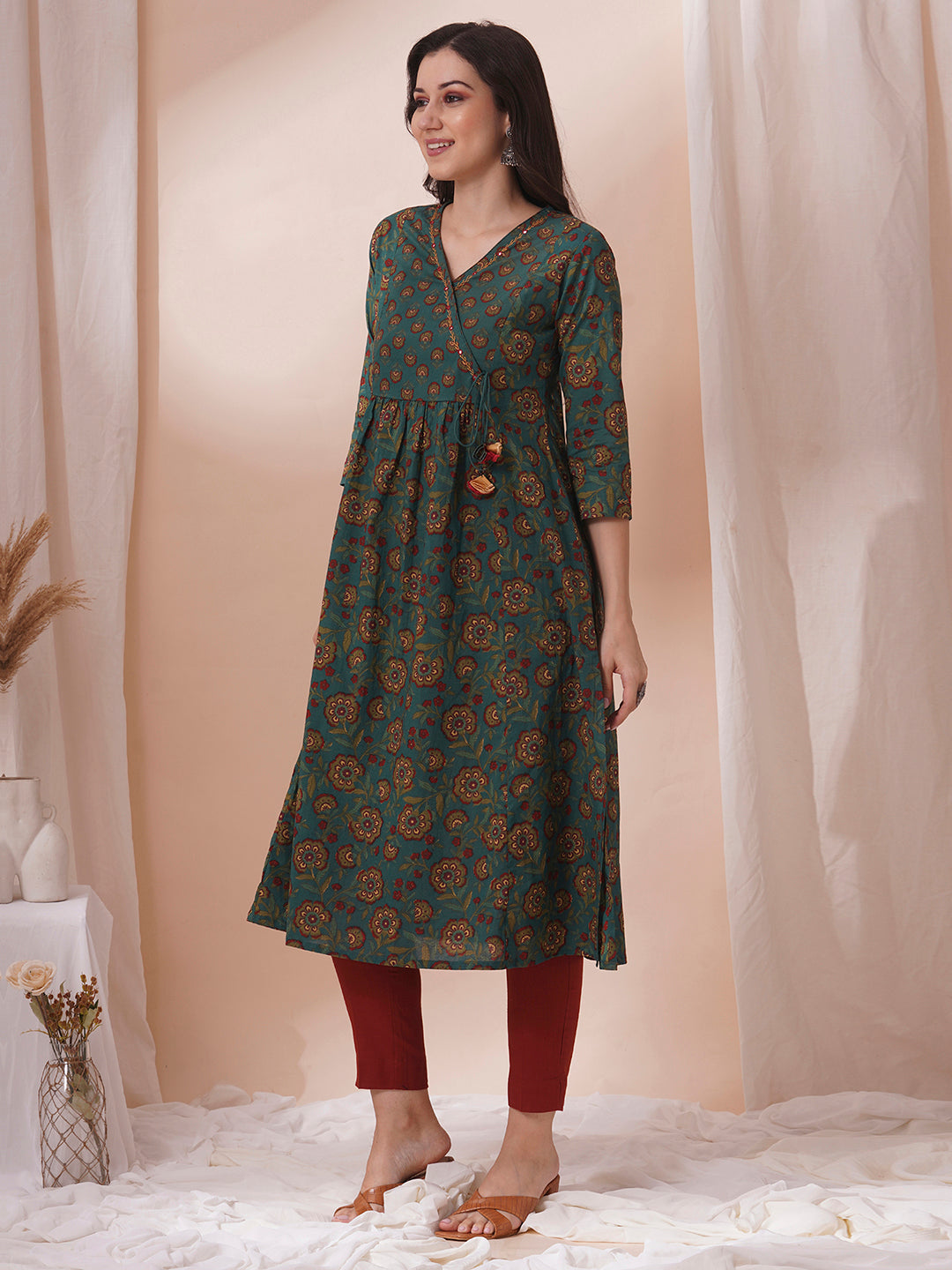 Fit and flare cotton print kurta with hand embroidery, overlap yoke and fabric tassels.