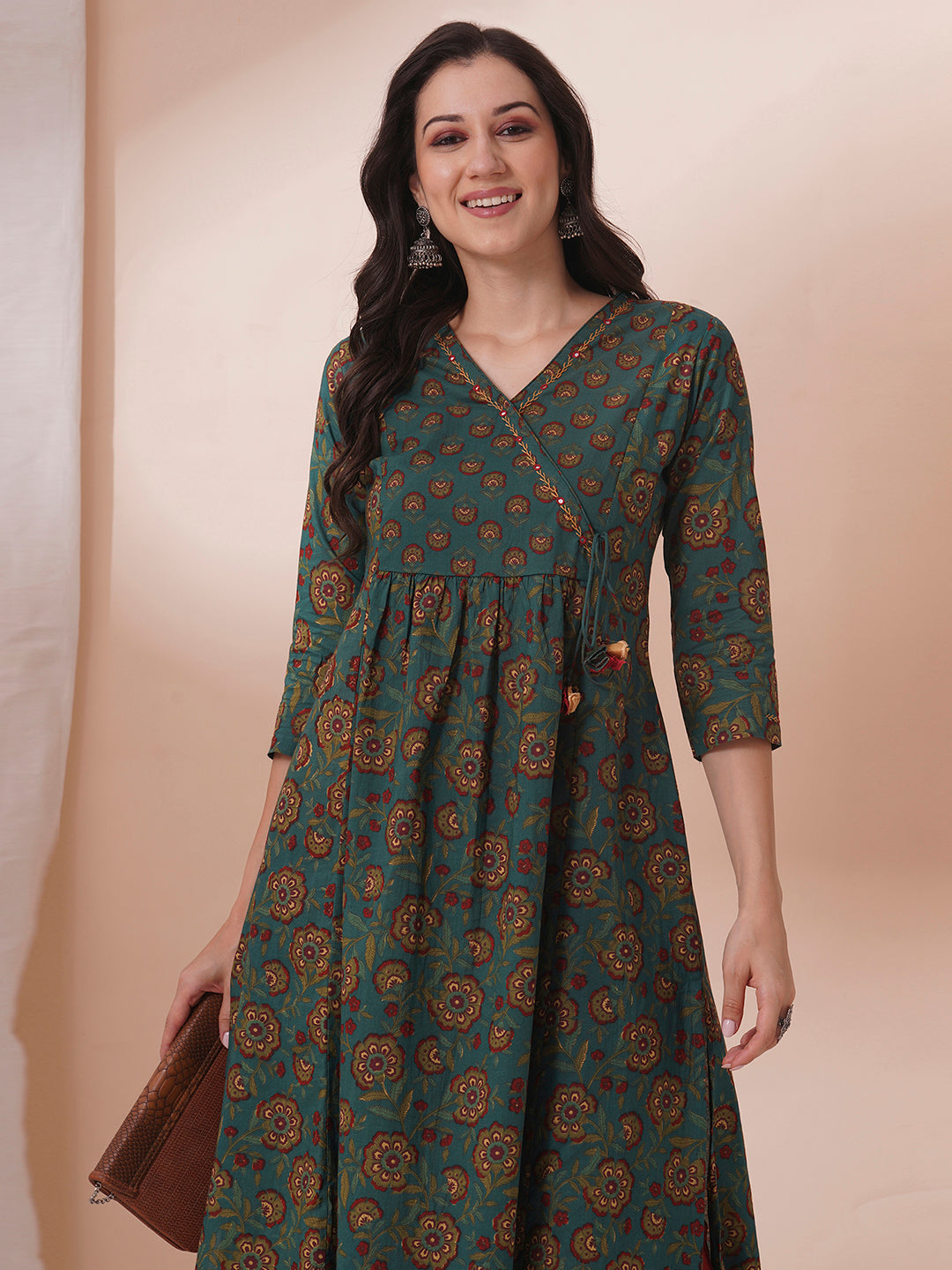 Fit and flare cotton print kurta with hand embroidery, overlap yoke and fabric tassels.