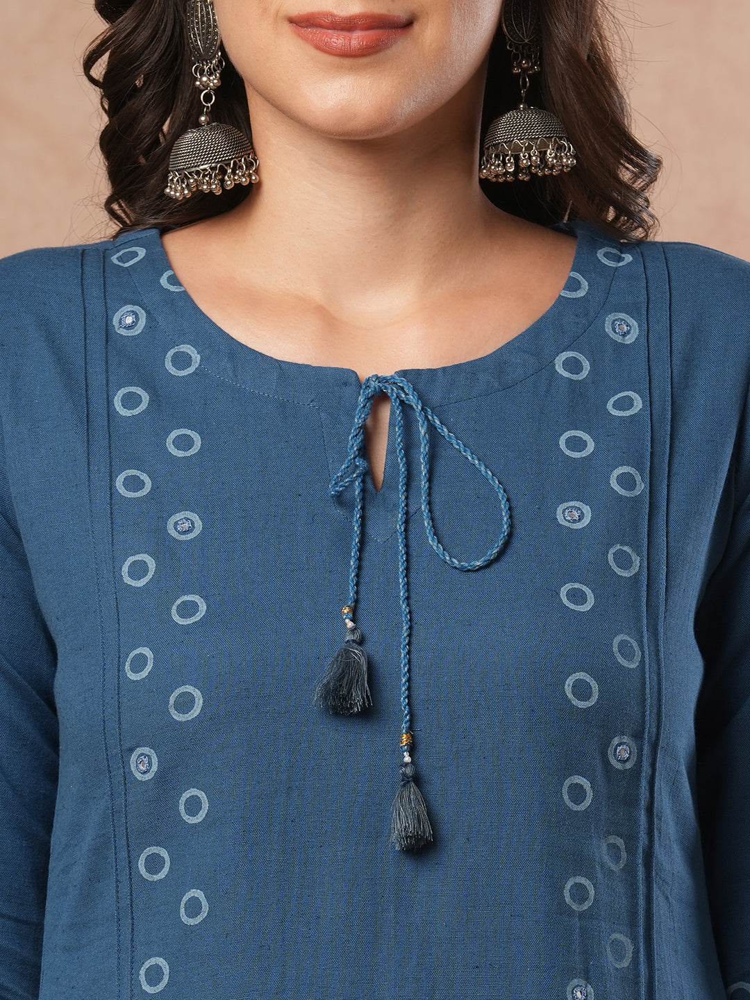 A-line cotton flex kurta with mirror work and attached thread tassels.