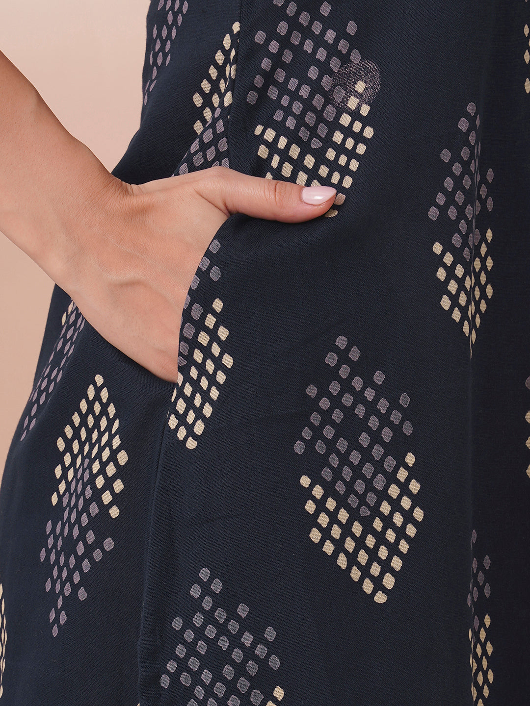 A centre box pleated sleeveless kurta with mirrorwork detailing on the neck.