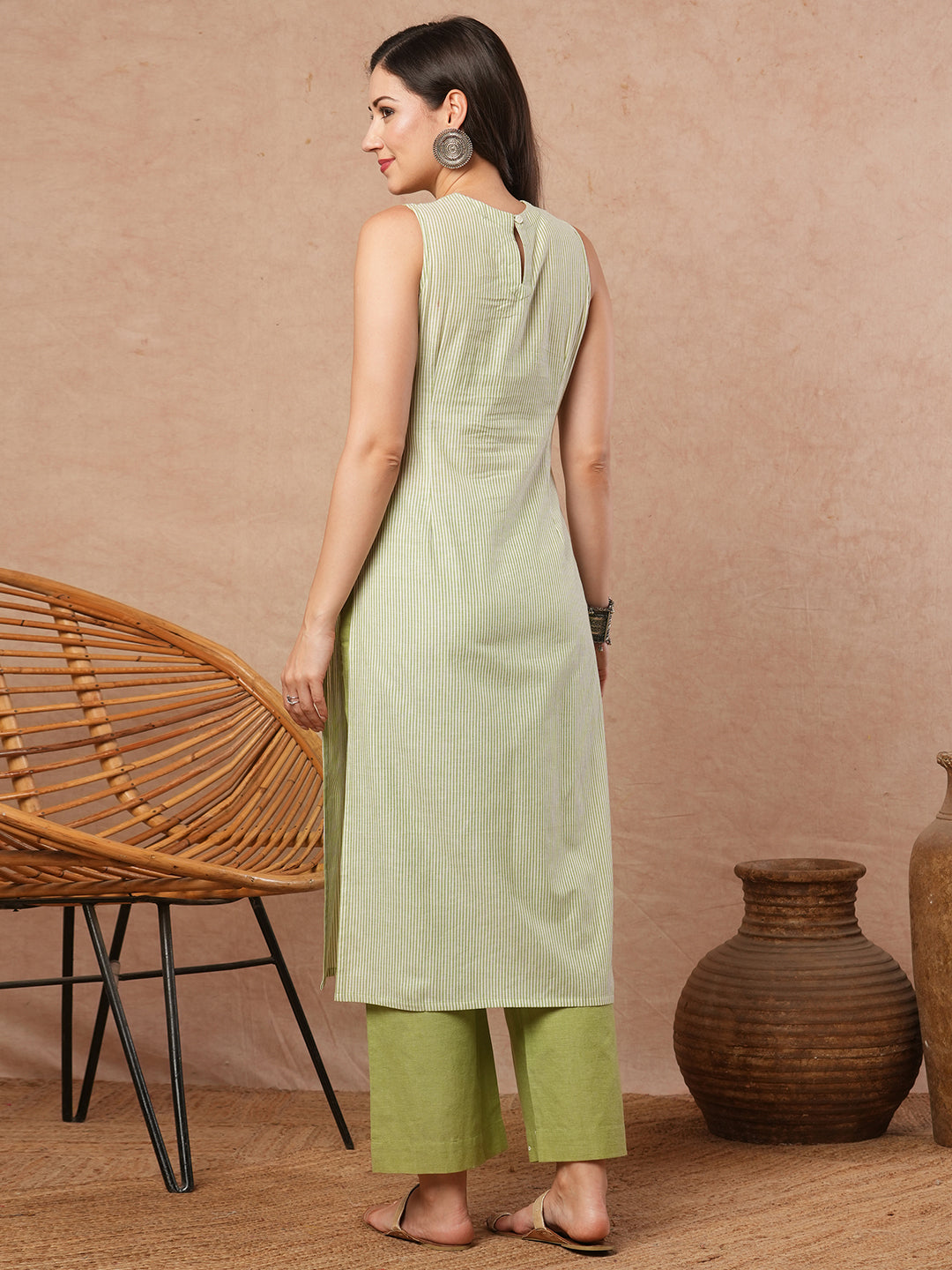 Sleeveless straight kurta with cutwork neckline and mirror work.