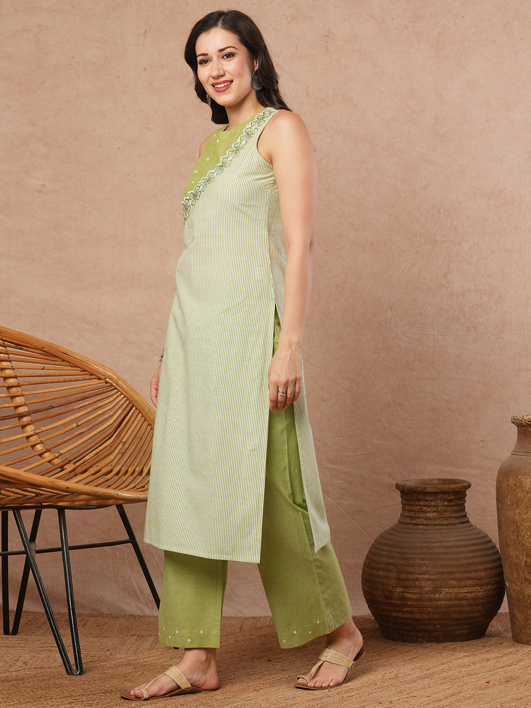 Sleeveless straight kurta with cutwork neckline and mirror work paired with palazzo.