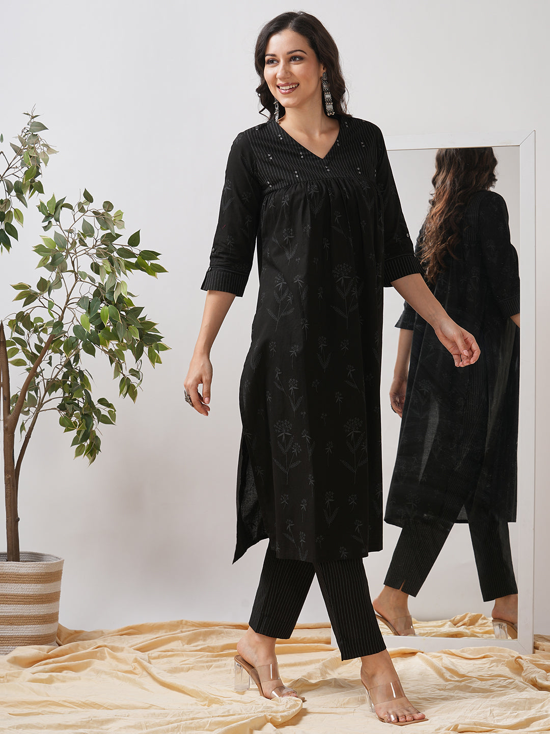 A gathered kurta set with mirrorwork shoulder yoke and cuffed sleeves paired with pant.