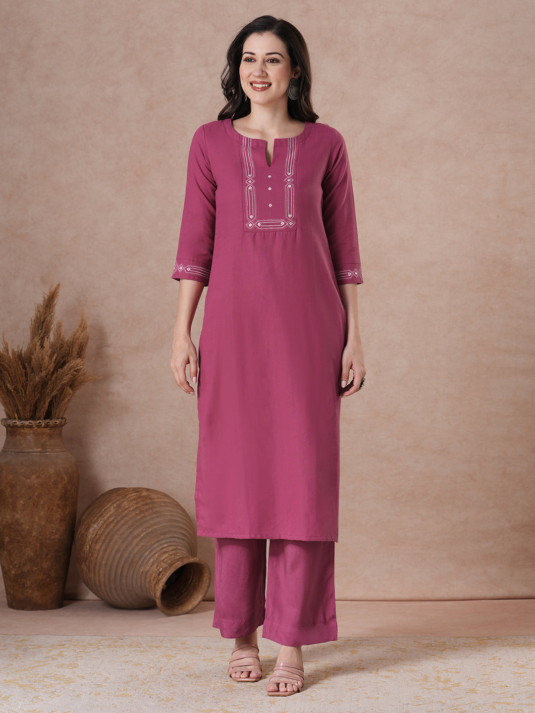A straight fit kurta with minimal monochromatic embroidery on the neckline.