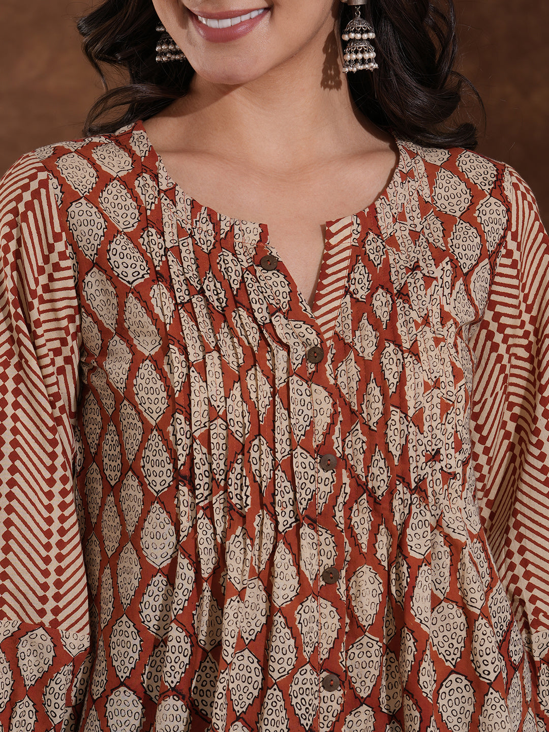 Hand block printed rust tunic with pleating and puff sleeves.