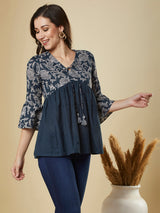 A navy blue shaped waist top with printed yoke and bell sleeves and gathered solid flare