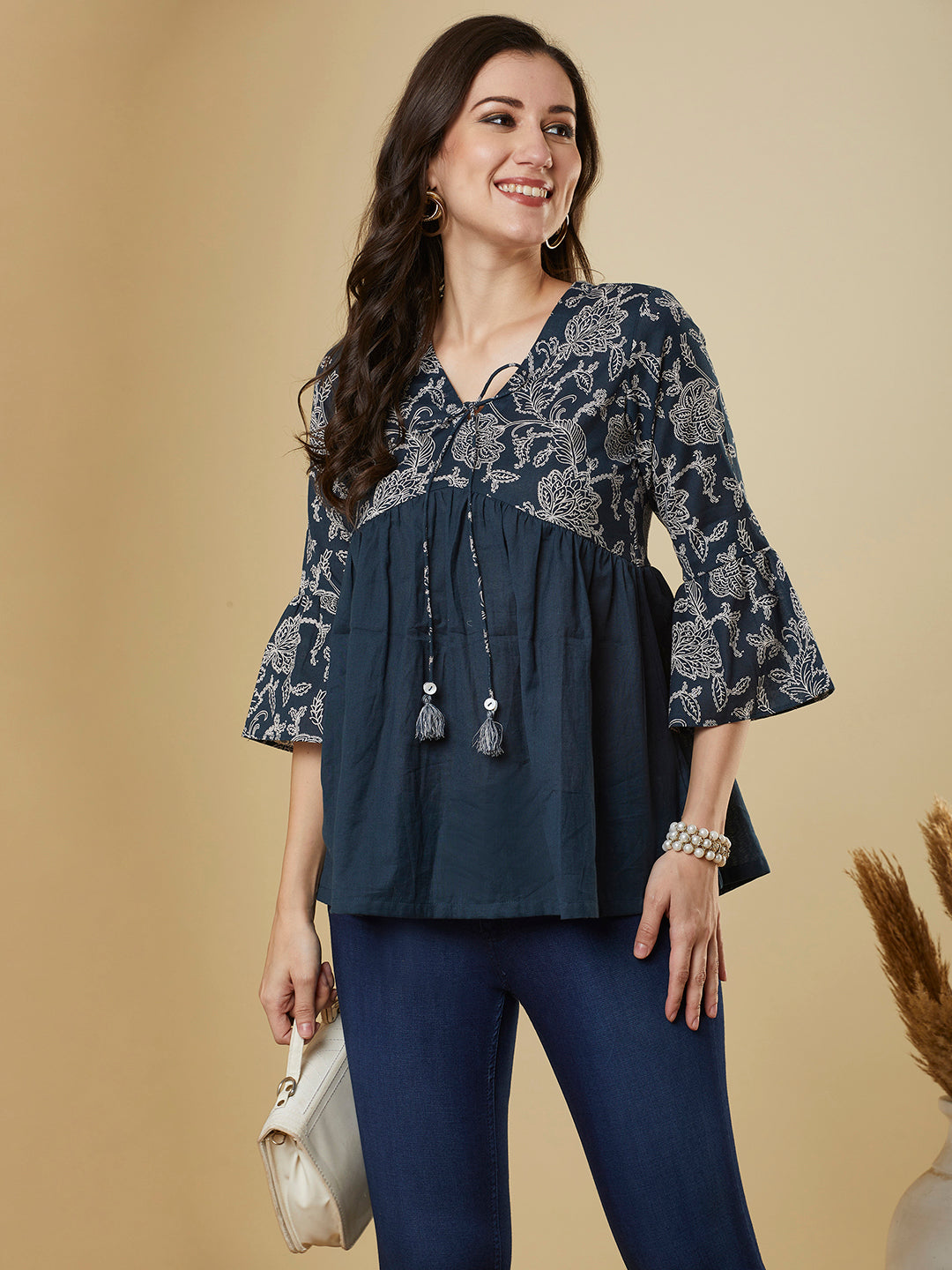 A navy blue shaped waist top with printed yoke and bell sleeves and gathered solid flare