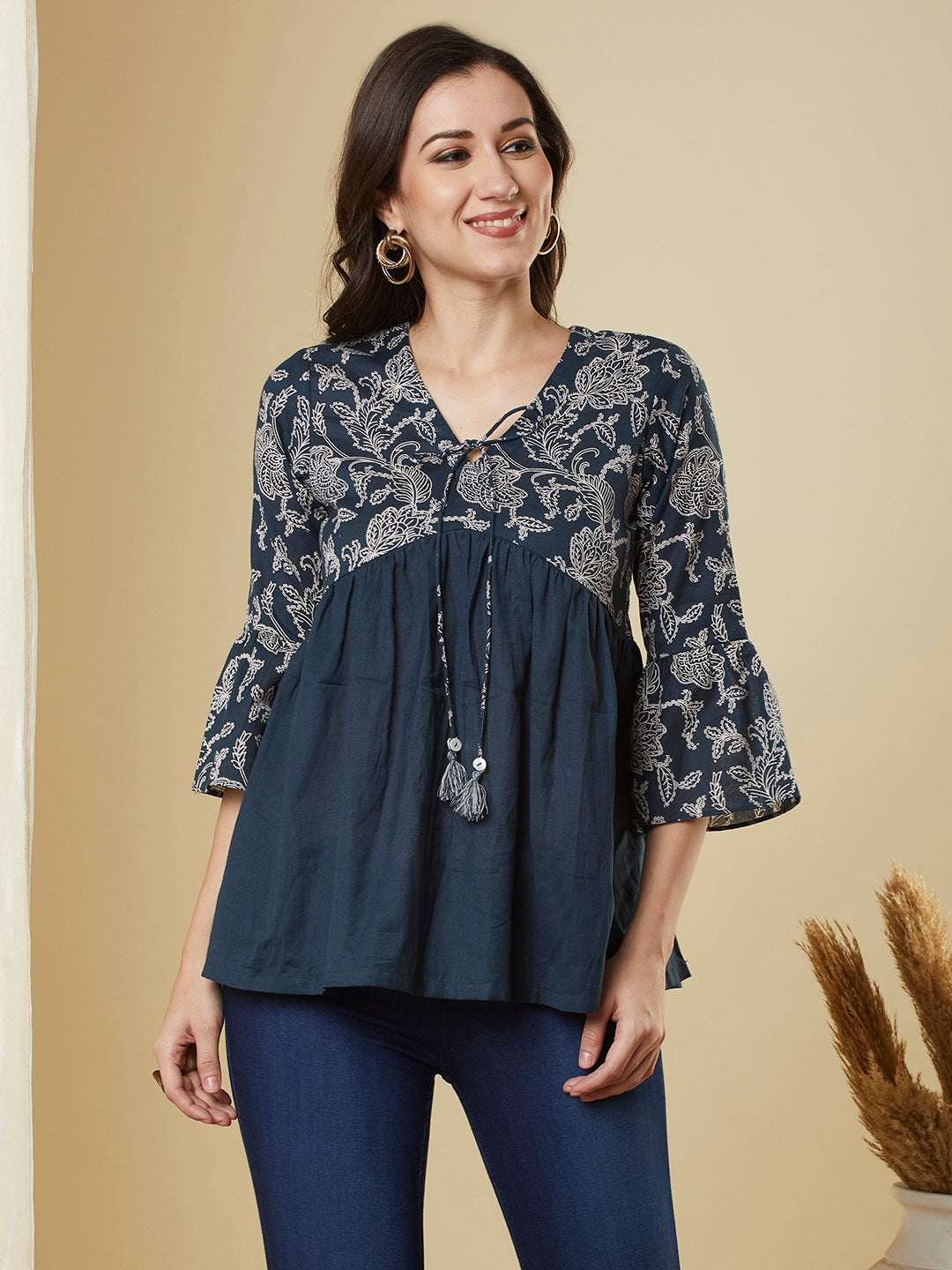 A navy blue shaped waist top with printed yoke and bell sleeves and gathered solid flare