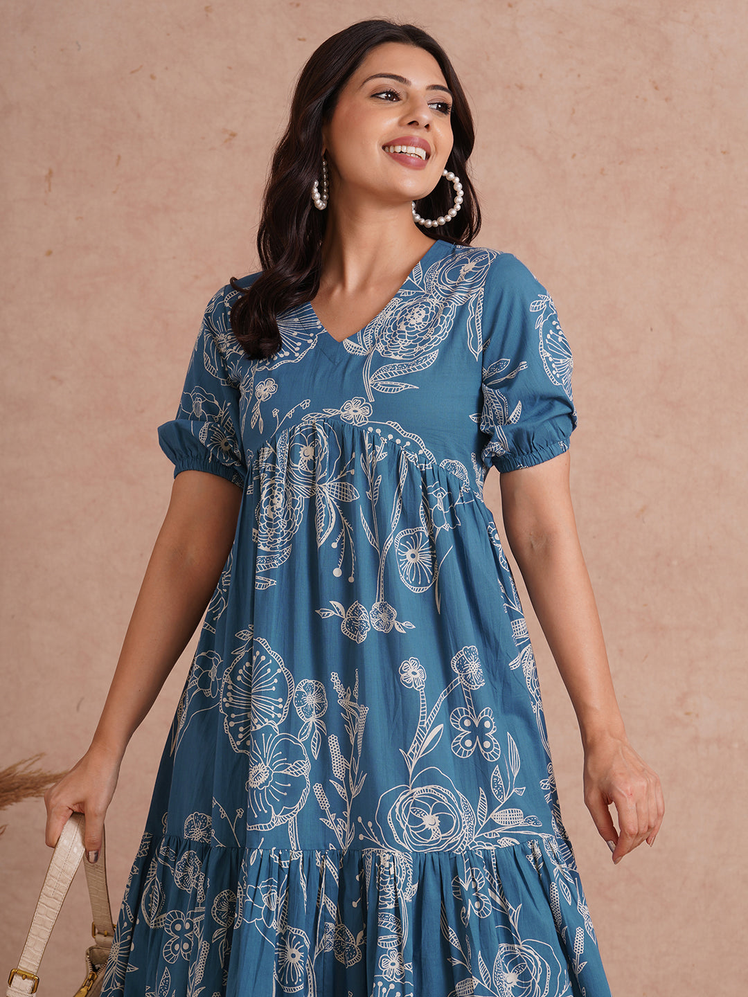 Tiered dress in printed cotton with an attached in seam pocket and puffed sleeves.