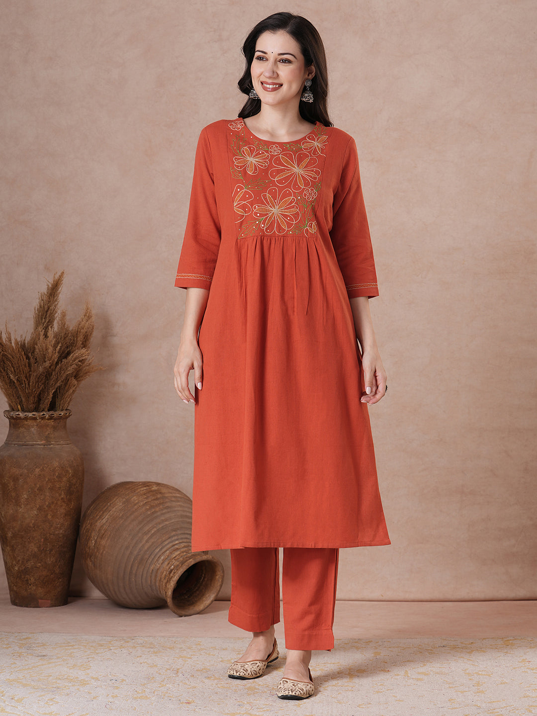 Rust Orange A-Line Kurta Set with Intricate Embroidered Yoke, Printed Dupatta and Matching Solid Pants.