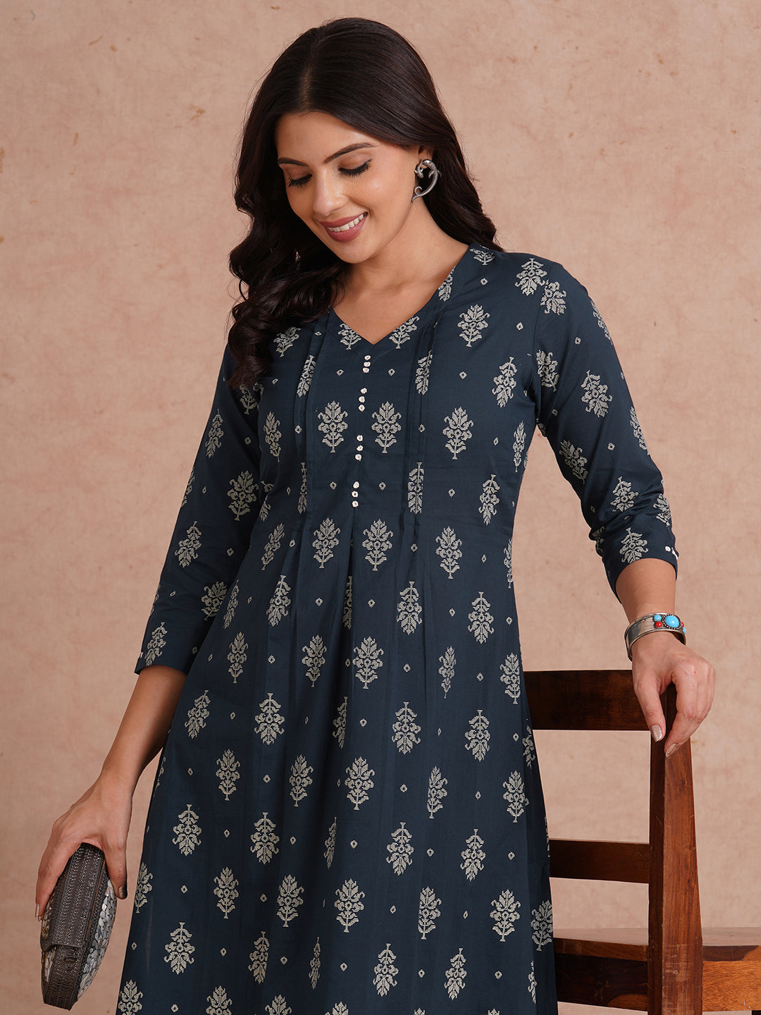 A-line kurta with tucks and box pleat in the front highlighted with handwork mirrors.