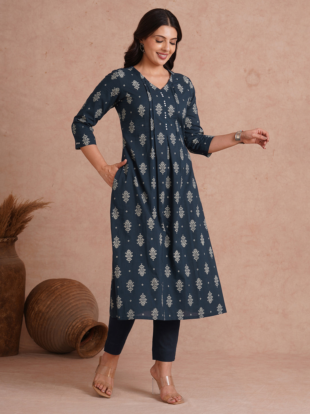 A-line kurta with tucks and box pleat in the front highlighted with handwork mirrors.