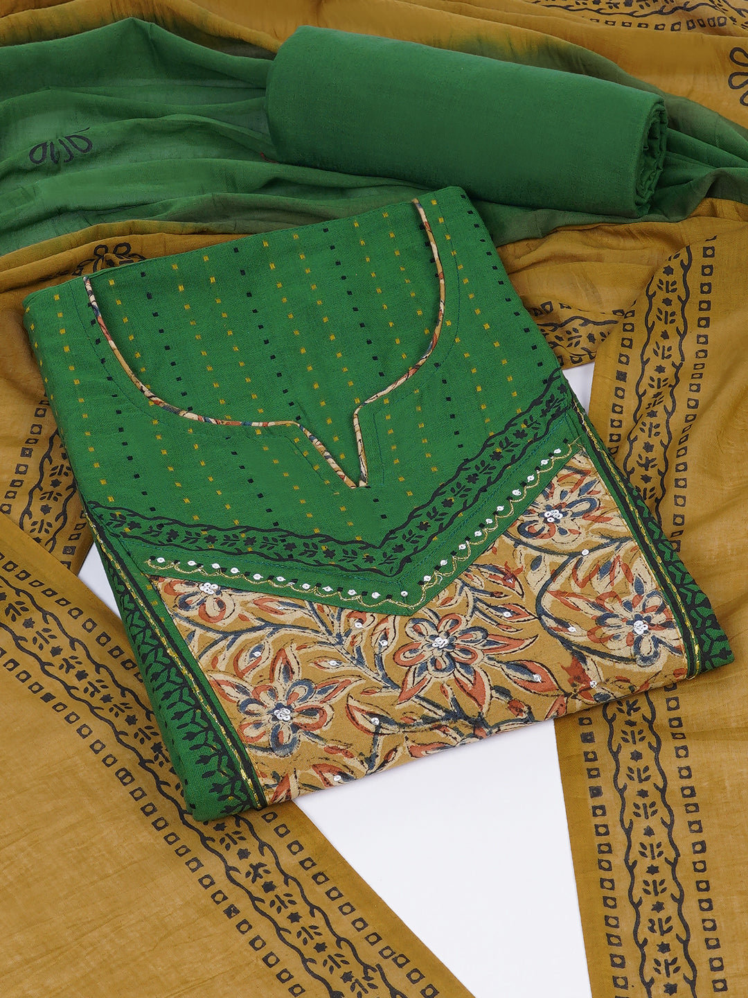 Unstitched suit set crafted in dobby fabric features a handcrafted Kalamkari printed patch.