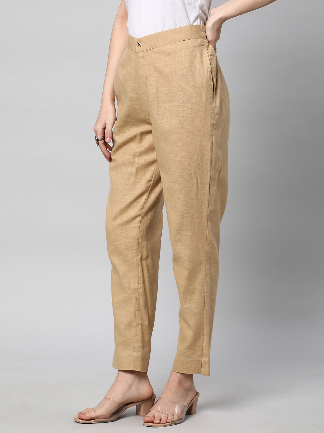 A beige ankle length cotton linen pant with plain belt in front