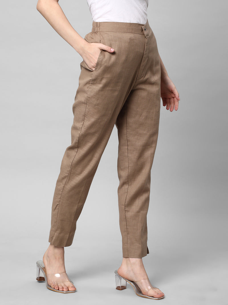 A brown ankle length cotton linen pant with plain belt in front.