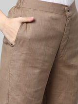 A brown ankle length cotton linen pant with plain belt in front.