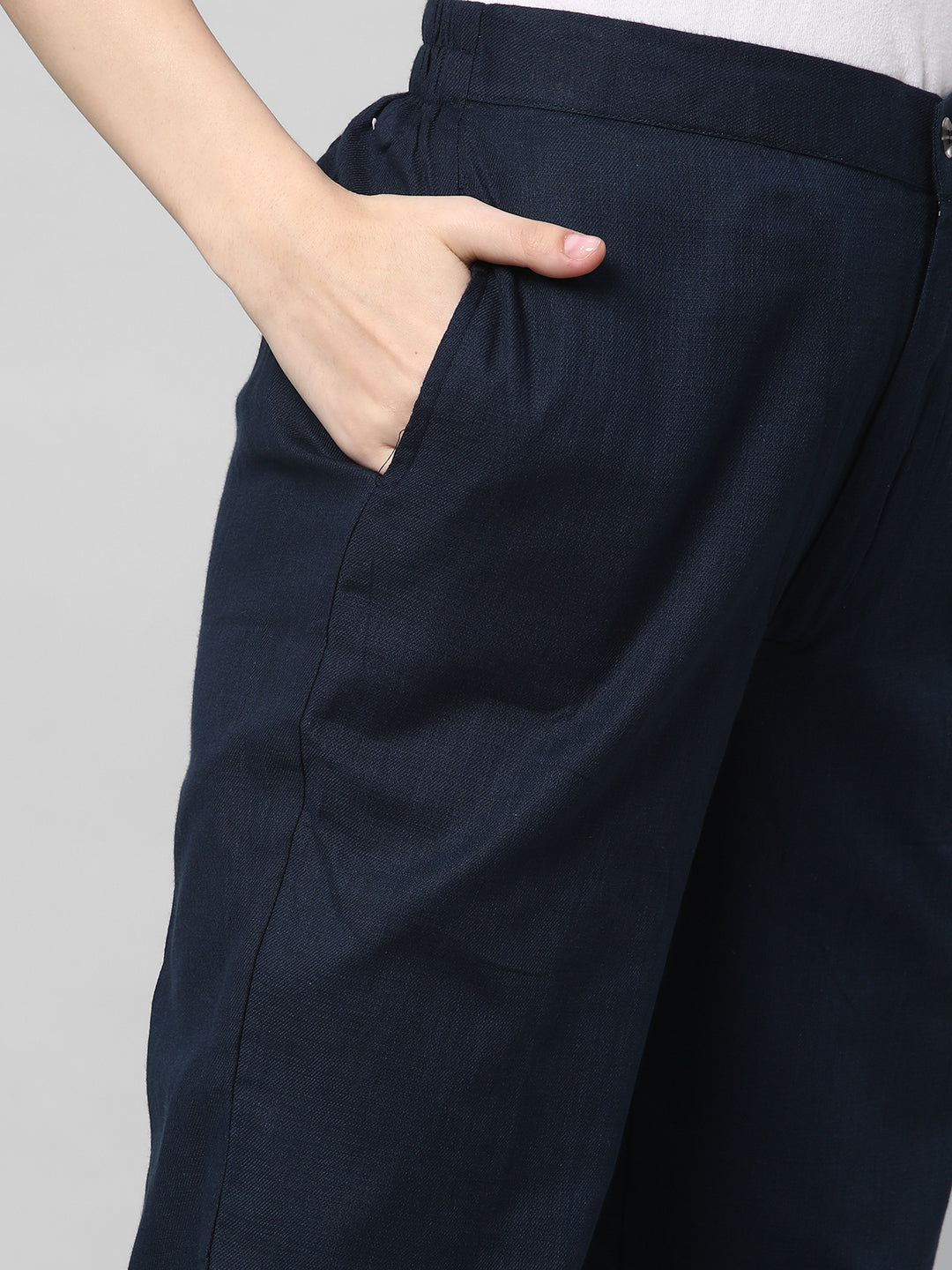 A blue ankle length cotton linen pant with plain belt in front