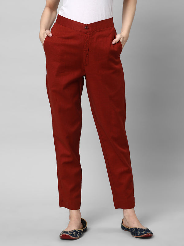 A Rust ankle length cotton linen pant with plain belt in front.