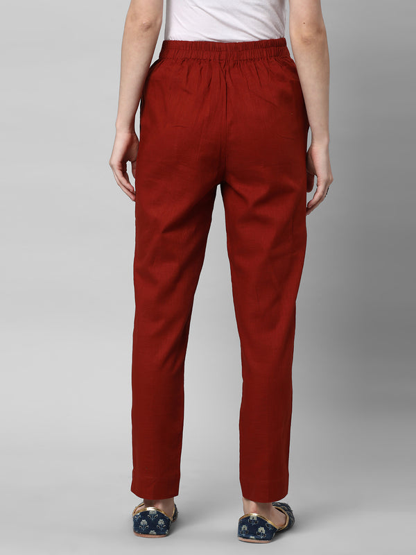 A Rust ankle length cotton linen pant with plain belt in front.