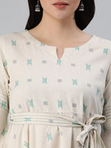 A flex flared tunic with pintucks and belt detail.