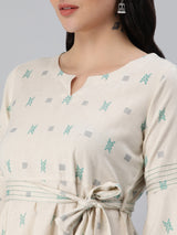 A flex flared tunic with pintucks and belt detail.