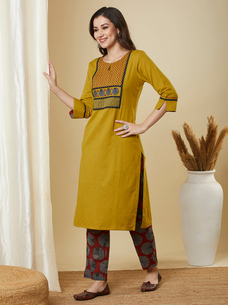 Mustard kurta suit set is paired with a printed bottom and a contrast color block-printed dupatta.