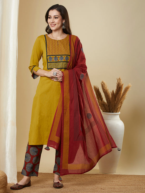 Mustard kurta suit set is paired with a printed bottom and a contrast color block-printed dupatta.