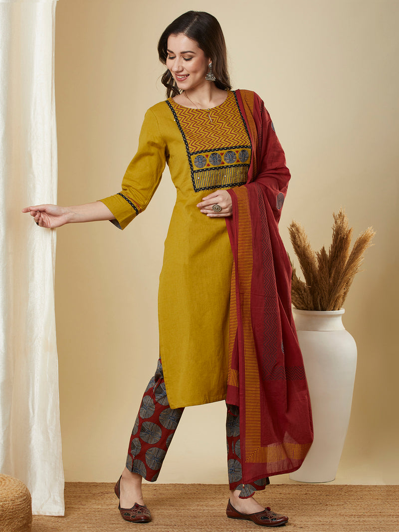 Mustard kurta suit set is paired with a printed bottom and a contrast color block-printed dupatta.