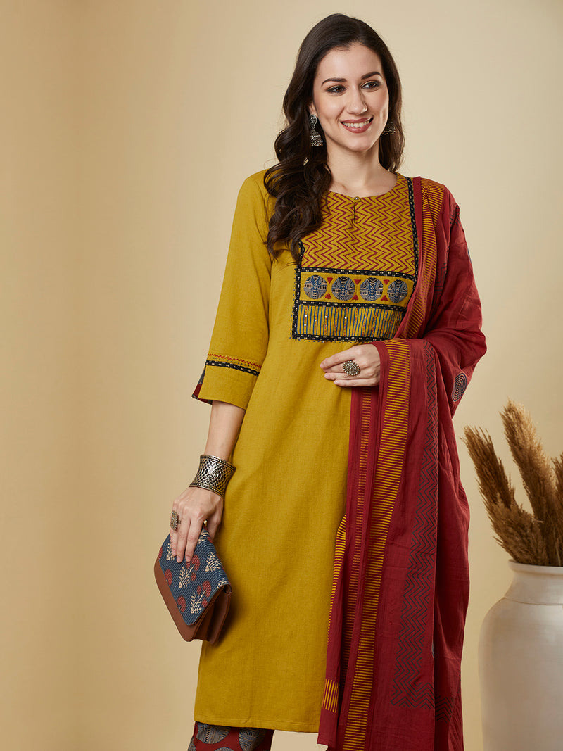 Mustard kurta suit set is paired with a printed bottom and a contrast color block-printed dupatta.