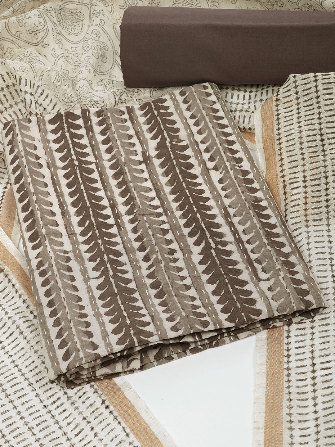 Brown unstitched suit set with traditional dabu print along with printed dupatta and solid bottom