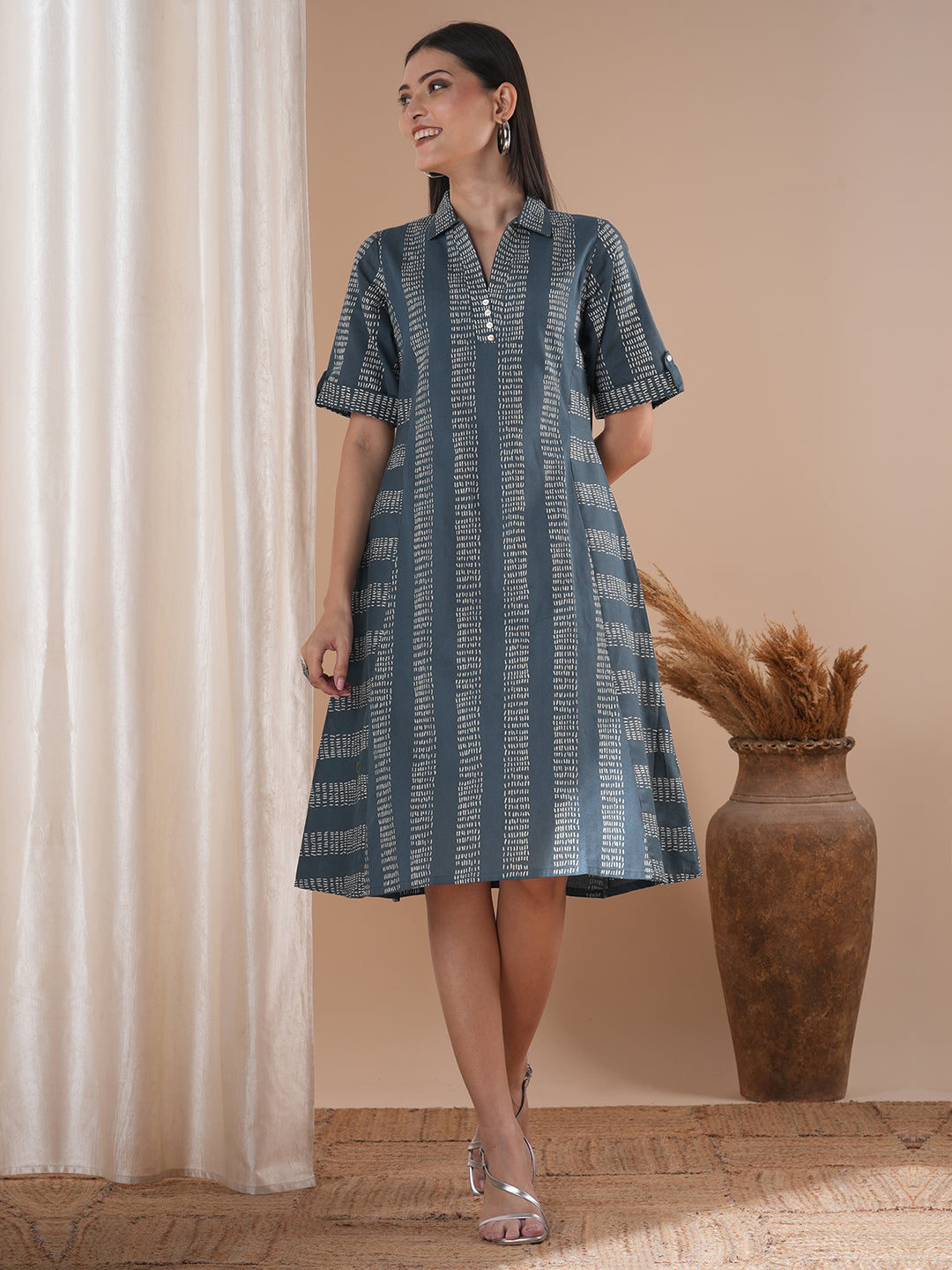A collared printed dress with stripe manipulation panels, dual pockets and half sleeves with cuff