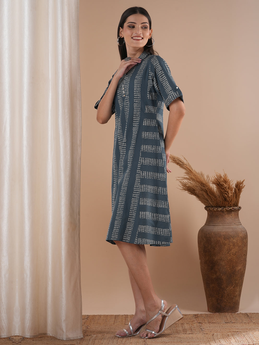 A collared printed dress with stripe manipulation panels, dual pockets and half sleeves with cuff