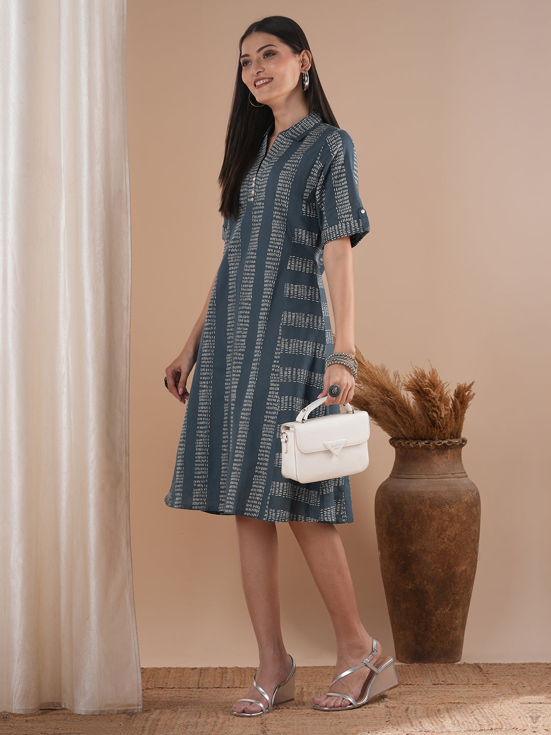 A collared printed dress with stripe manipulation panels, dual pockets and half sleeves with cuff