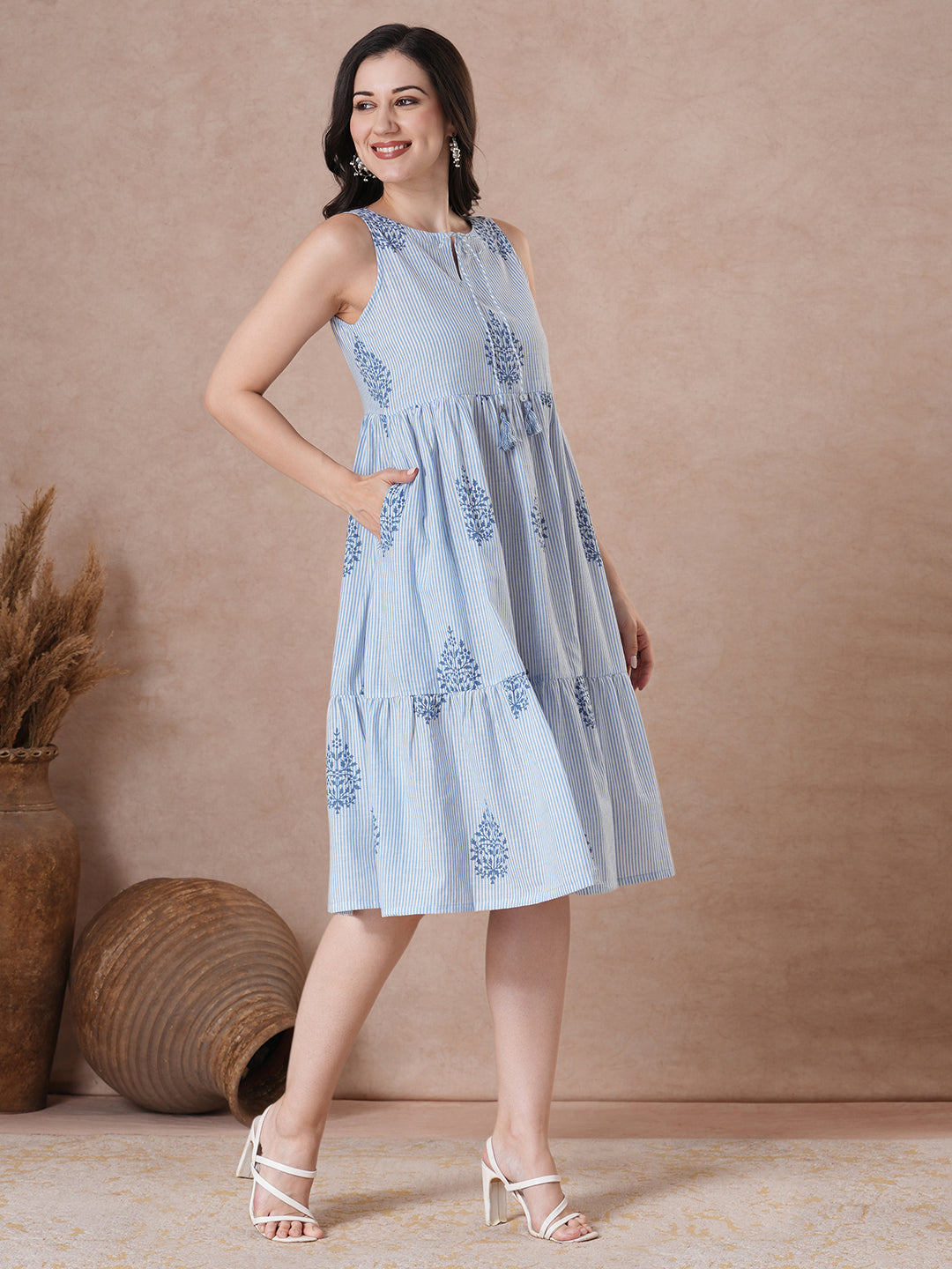 Woven striped and screen printed tiered dress with tie-up on neck with tassels.