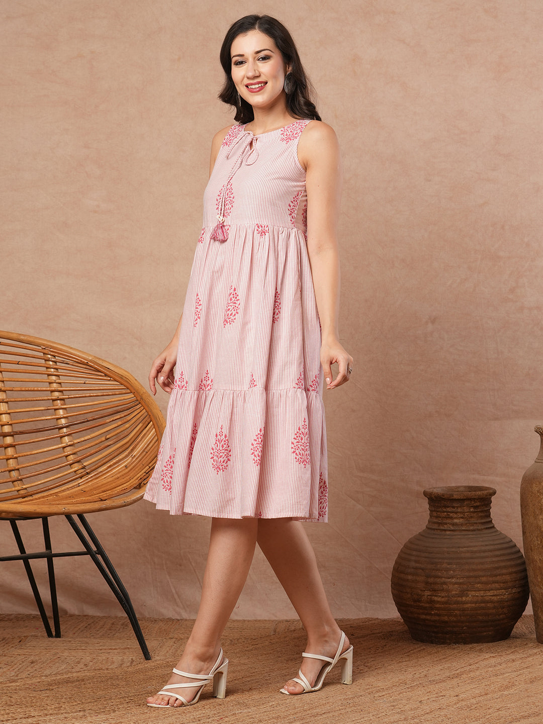 Woven striped and screen printed tiered dress with tie-up on neck with tassels.